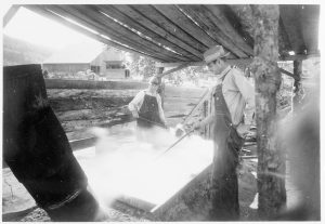 Two men skim boiling sorghum in a park demonstration circa 1930. It takes some approximately ten gallons of sorghum juice to render one gallon of syrup. Photo by Carlos C. Campbell, provided by GSMNP Archives.