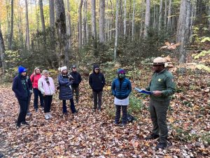 Science Communicator Antoine Fletcher (right) leads a presentation on the history of the Elkmont area for a group from the National Parks Conservation Association. Provided by NPS.