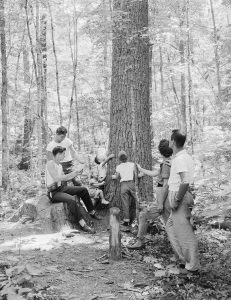 A family enjoys a hike using a self-guiding brochure, one of Henry Lix’s favorite interpretive tools. These brochures referenced numbered signposts, like the one seen here, highlighting interesting features along the trail. Provided by GSMNP archives.